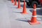 Orange cones in the parking lot with the car.