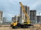 Orange construction excavator loading old tram rails into truck timelapse. Industrial workers with hardhats and uniform.