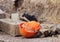 orange construction helmet, Scotch and footwear lies on the edge of the ditch, where the reconstruction works water pipes.