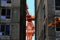 Orange construction tall crane between residential buildings under construction illuminated by early morning sunlight.