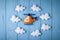 Orange craft helicopter and clouds on blue wooden background with copyspace. Felt handmade toys. Empty space for text. Top view.