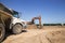 Orange crawler excavator and an articulated construction dumper work in a sandy quarry