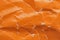Orange crumpled paper background with folds texture