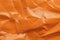 Orange crumpled paper background with folds texture
