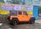 A orange crush late model Jeep Wrangler