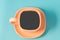 orange cup coffee on a blue background/orange cup with a saucer full of black coffee on a blue background, top view