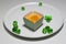 Orange cupcake and topping with orange sacs and jelly green round in the white dish.