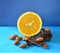 Orange, dark chocolate, almonds on blue surface and background