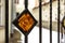 Orange decorative stained glass element in metal fence