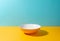 Orange deep plate on yellow and blue background