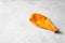 Orange deflated balloon on grey background