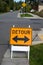 Orange detour sign with double arrow at an intersection in a residential neighborhood