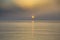 Orange disk of the sun setting over the sea during sunset on the Mediterranean sea