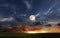 Orange dramatic sunset on wild field sun down and moon rise on starry cloudy  sky green grass nature landscape