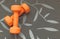 Orange dumbbell for fitness isolated on grey background