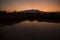 Orange dusk Mountains reflected in lake