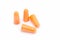 Orange earplugs with a string on white background.