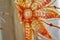Orange embroidered flower on a delicate sheer curtain fabric