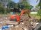 orange excavator or macro truck mover machine working in trash land construction site separate garbage on soil