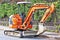 Orange excavator parked at the roadside