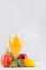 Orange exotic juice of different fruits - mango, kiwi, banana, pear, peach - with ingredients on white wooden background.