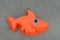 An orange fish sand toy at the beach