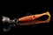 Orange fishing lure, plastic shad fish, with double hook and lead sinker, isolated on black