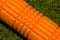 Orange foam roller on green background