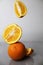 orange fruits citrus oranges flying falling arugula orange on a gray background. Creative shooting. vitamins citrus health