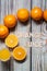 Orange fruits surrounding orange juice wooden letters with juicy vase on a wooden surface