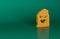 Orange Funny and scary ghost mask for Halloween icon isolated on green background. Happy Halloween party. Minimalism