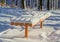 Orange garden bench covered with fluffy snow