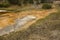 Orange geothermal stream runs over carbonate rocks, Yellowstone