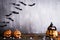 Orange ghost pumpkins with witch hat on gray wooden board background with bat. halloween concept