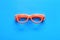 Orange glasses on a blue background