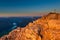 Orange glowing rocks of mountain peak with cross