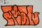 Orange graffiti word in SE Portland, Oregon