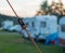 Orange guy rope of a tent with a knot in front of a camping pitch