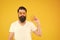 Orange is the happiest color. Bearded man holding orange on yellow background. Hipster with healthy orange snack