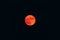 Orange haze over blurry red full moon, low visibility from wildfires smoke, San Francisco, California, United States