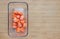 Orange heart from carrot Cubes in square glass bowl on wooden board with copy sapce. Frozen baby food homemade