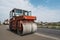 Orange Heavy Vibration roller compactor at asphalt pavement works for road repairing. Working on the new road