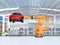 Orange heavyweight robotic arm carrying red SUV in the assembly factory
