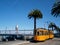 Orange historic streetcar of the F-Line MUNI Train, original from Milan, Italy, filled with people in front of the Bay Bridge and
