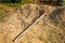 Orange hoe wooden handle in traditional agriculture farming.The light shining to the hoe in sunny day on farm soil background.