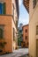 Orange houses and a pavement in Spoleto city narrow streets on sunny morning