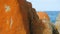 Orange-hued granite rocks with sea water