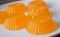 Orange jelly in small molds on white plate