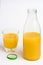 Orange juice, glass and bottle uncovered