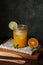 Orange juice in glass with mint, fresh fruits on wooden board.